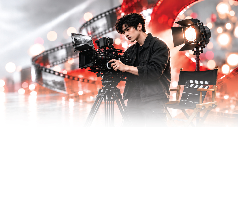 Student operating a film camera on set beside a studio light and director’s chair